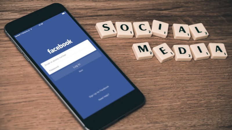 space gray iPhone 6 with Facebook log-in display near Social Media scrabble tiles - Social Media Facebook, tags: content-erstellung - unsplash
