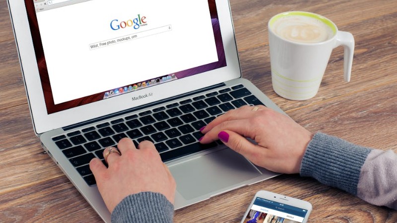 Hands typing on MacBook Air with Google search open, coffee nearby. - Hands typing on MacBook Air with Google search open, coffee nearby., tags: für euren blog - pexel