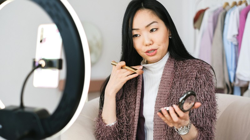 Beauty vlogger demonstrating makeup tips using a ring light during live stream., tags: wie sozialen reise - pexel